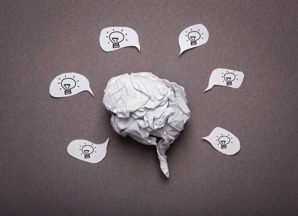 Crumpled paper brain shape with light bulb