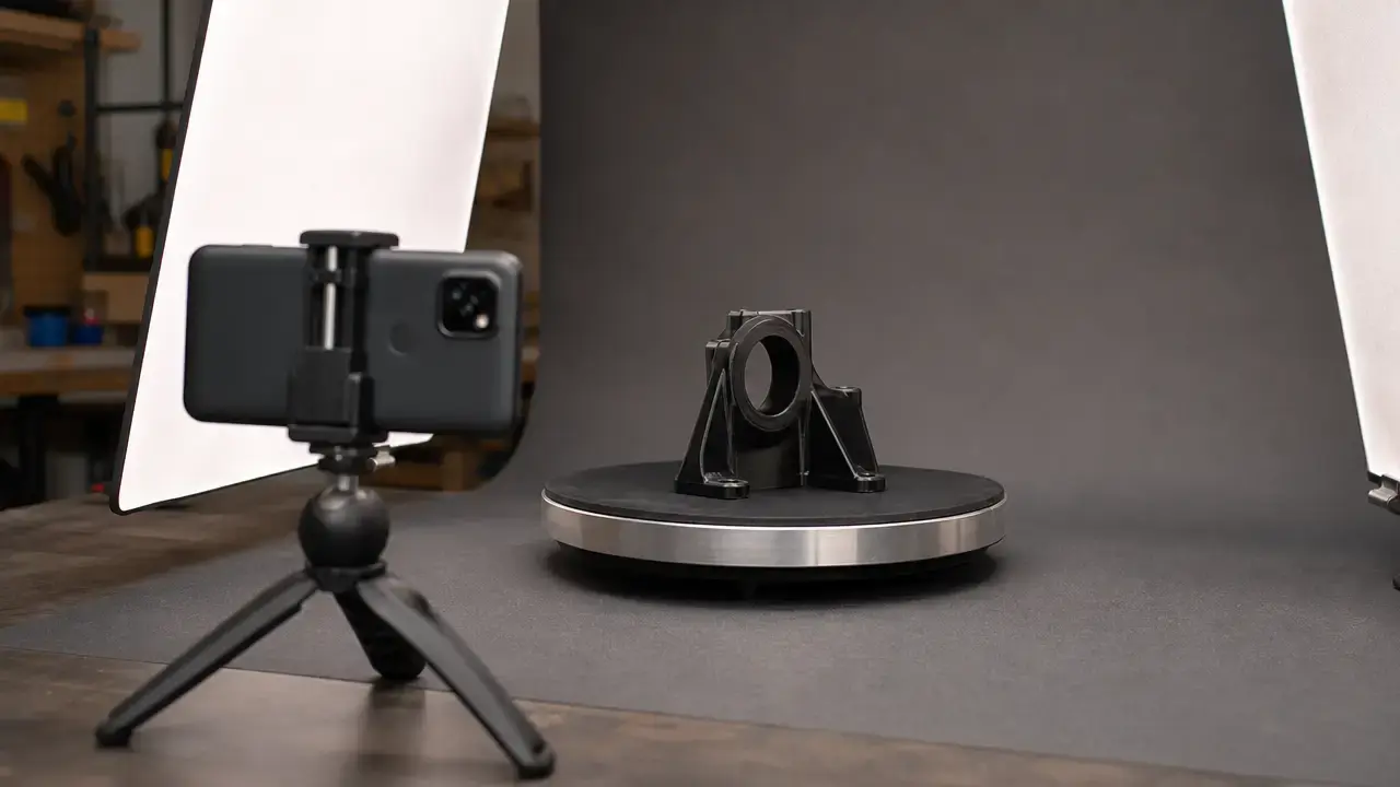 Android phone photographing a 3D-printed bracket on a turntable under diffuse light.