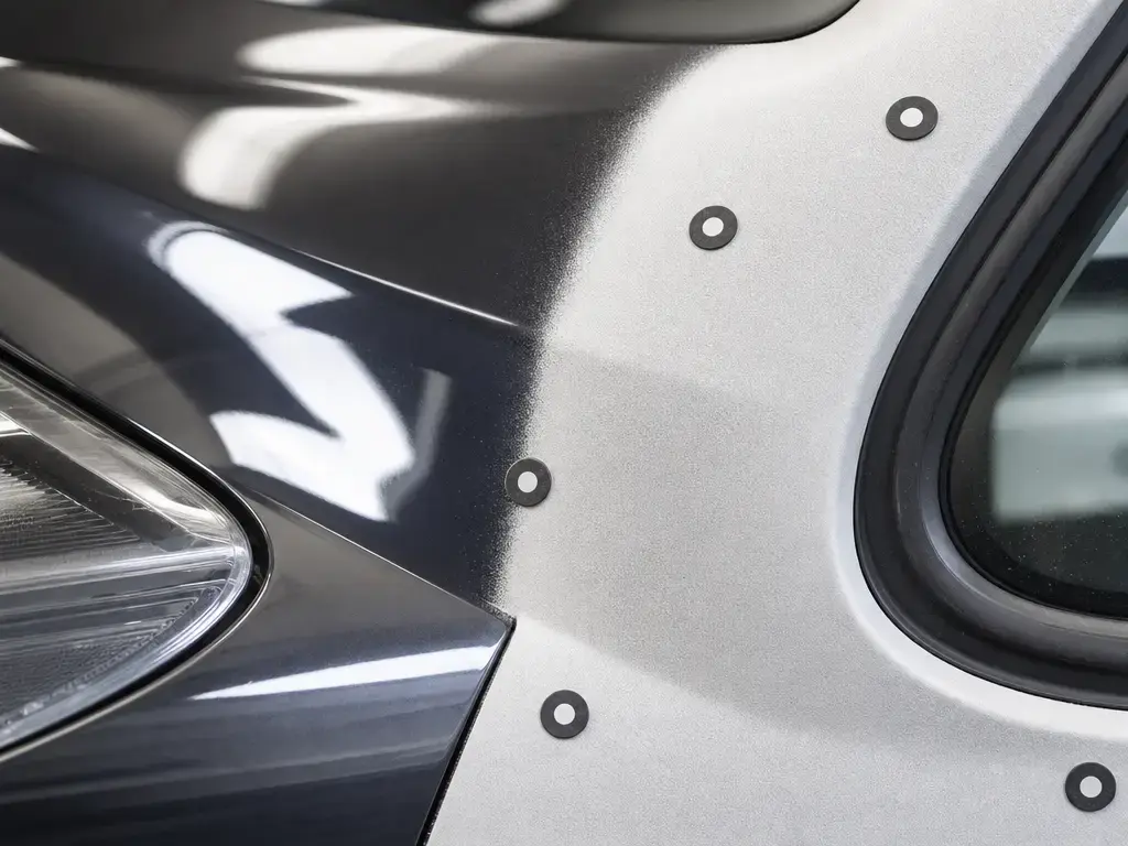 Prepared car panel with matte scan coating and tracking targets beside glossy paint