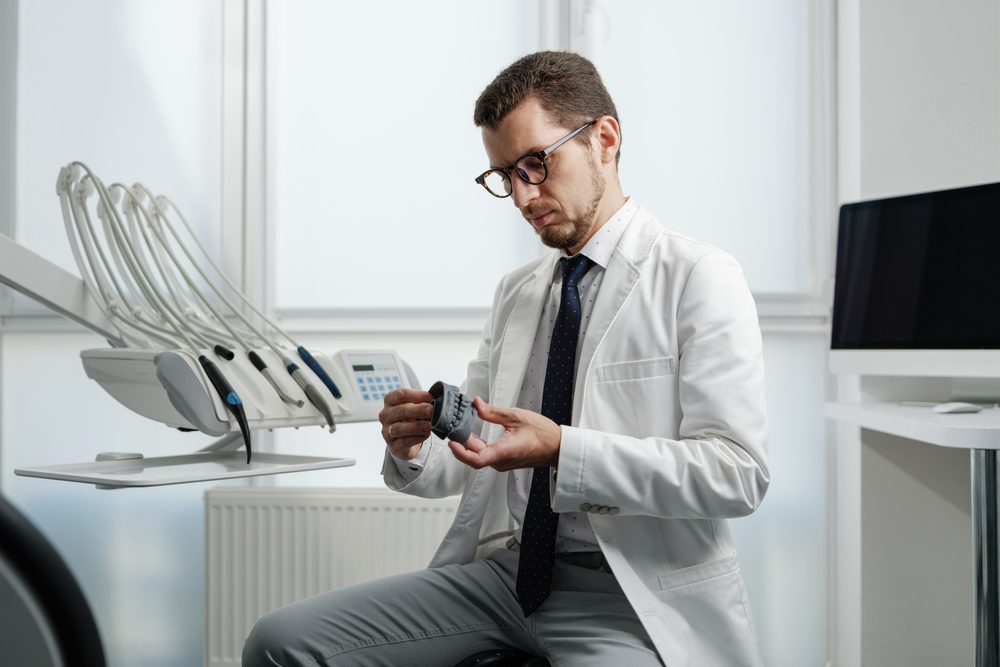 dentist look at 3d printed teeth